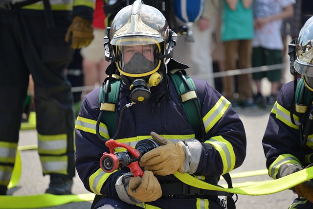 Imagem bombeiro securando uma mangueira de incêndio.